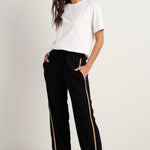 Model wears black track pant