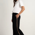 Model wears black track pant