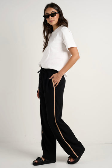 Model wears black track pant