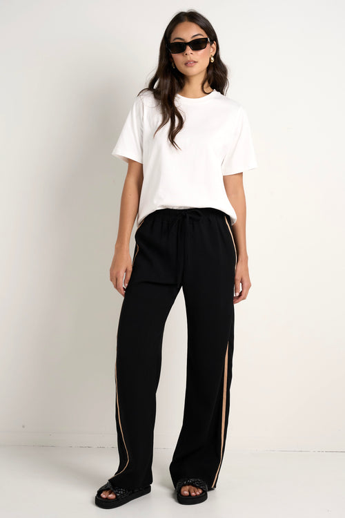 Model wears black track pant