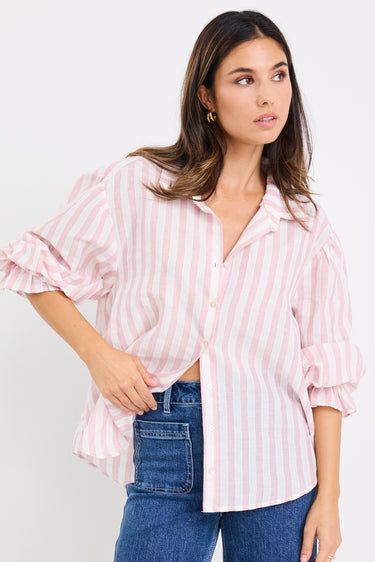 model wears a pink and white stripe shirt with dark blue jeans