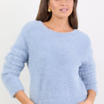 Woman wearing a light blue sweater against a white background