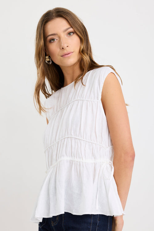 model wearing white linen top with ruched tie details 