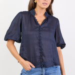 Woman wearing a navy blue blouse and blue jeans on a white background