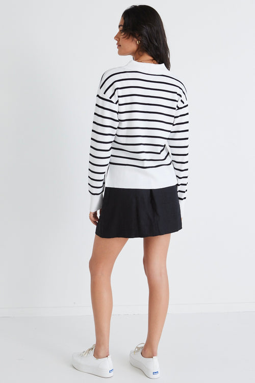 model wears a striped black and white jumper and black skirt