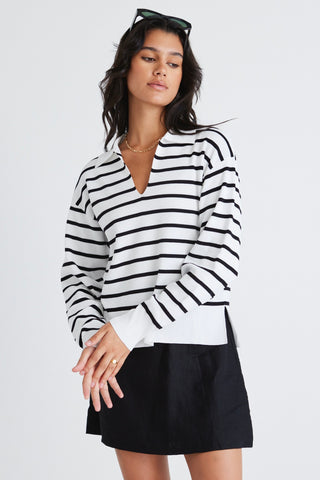 model wears a striped black and white jumper and black skirt