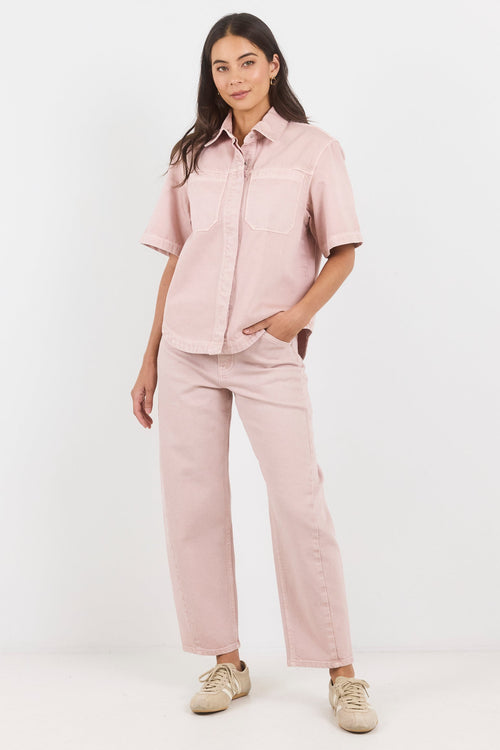 Woman wearing a pink outfit with a shirt and pants on a white background