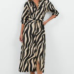 Woman wearing a zebra print dress on a white background
