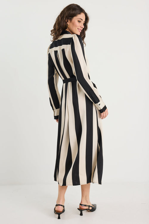 Woman wearing a black and white striped dress on a white background