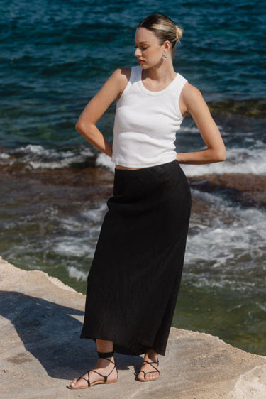 Woman standing on a rocky outcrop by the ocean