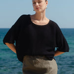 Woman standing on a beach with ocean in the background