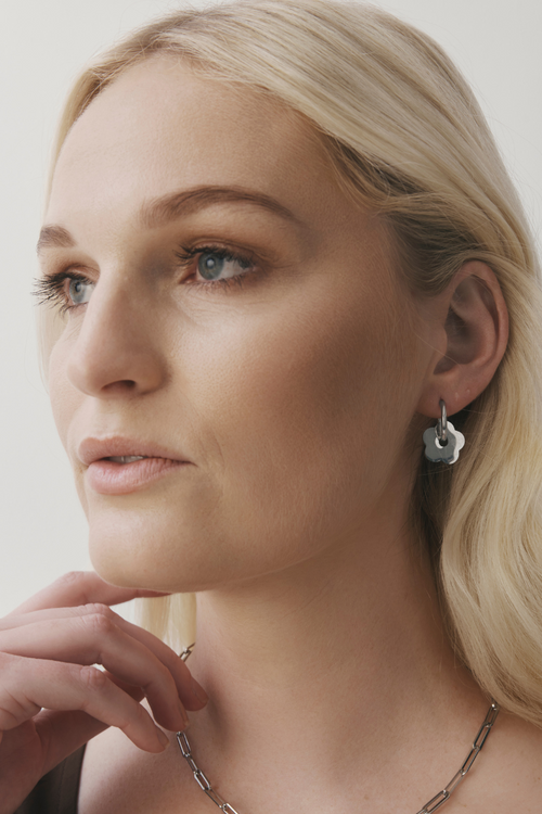 Close-up of a woman wearing earrings with a neutral background