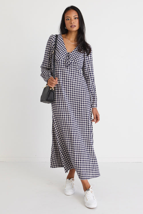 model wears a navy gingham dress