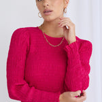 Model wears a long sleeve pink blouse