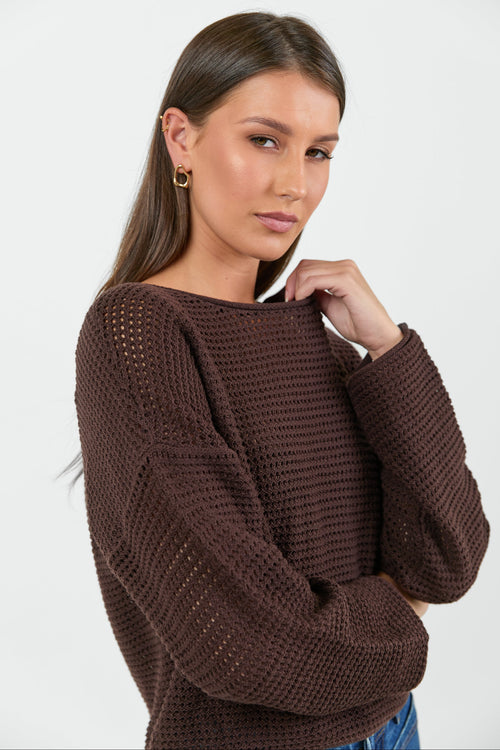 Woman wearing a brown knitted sweater on a white background