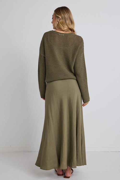 model wears a green knit jumper and a green linen maxi skirt