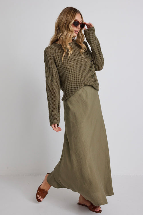 model wears a green knit jumper and a green linen maxi skirt