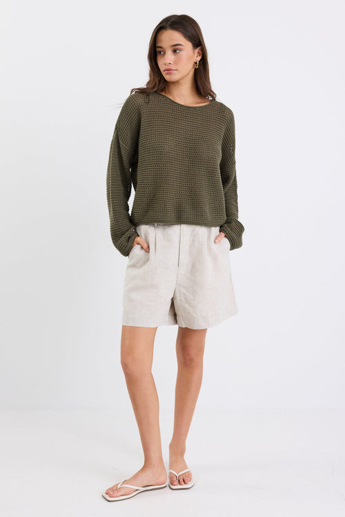 woman wearing a khaki jumper and cream short