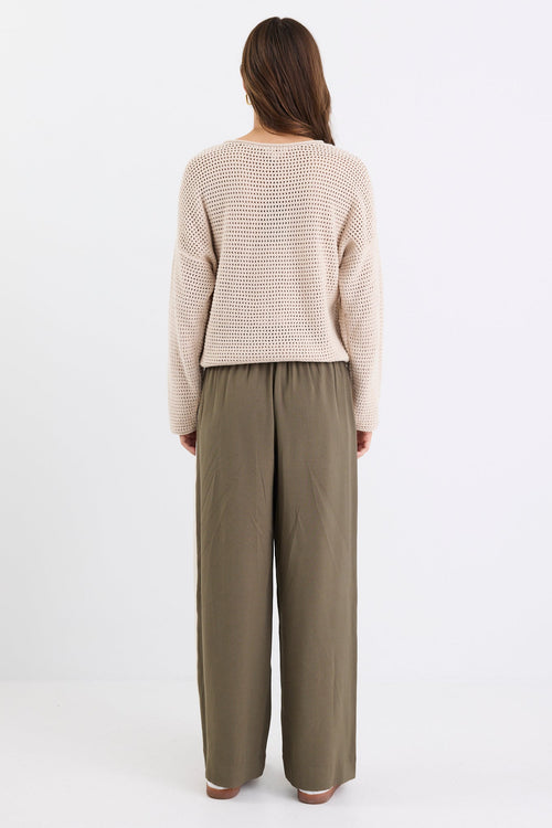 Woman wearing a beige crochet knit and khaki pant