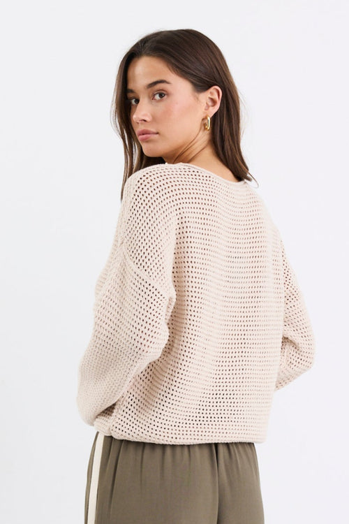 Woman wearing a beige crochet knit and khaki pant