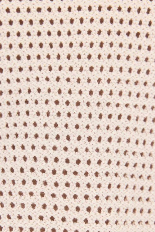 Textured fabric pattern with small brown dots on a beige background