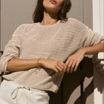 model wears biege knit top