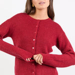 Woman wearing a red knitted cardigan on a white background