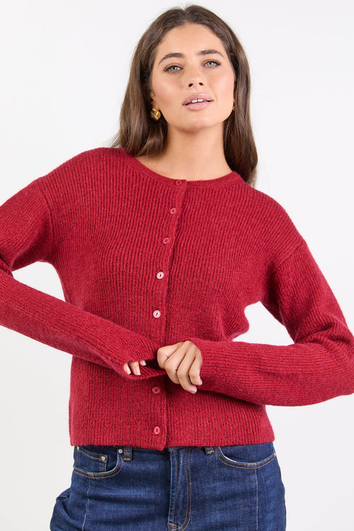 Woman wearing a red knitted cardigan on a white background