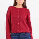 Woman wearing a red sweater and blue jeans on a white background