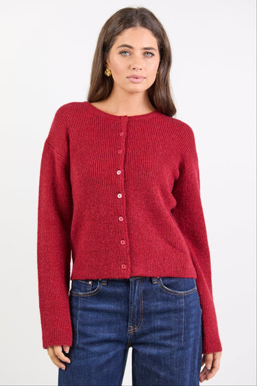 Woman wearing a red sweater and blue jeans on a white background