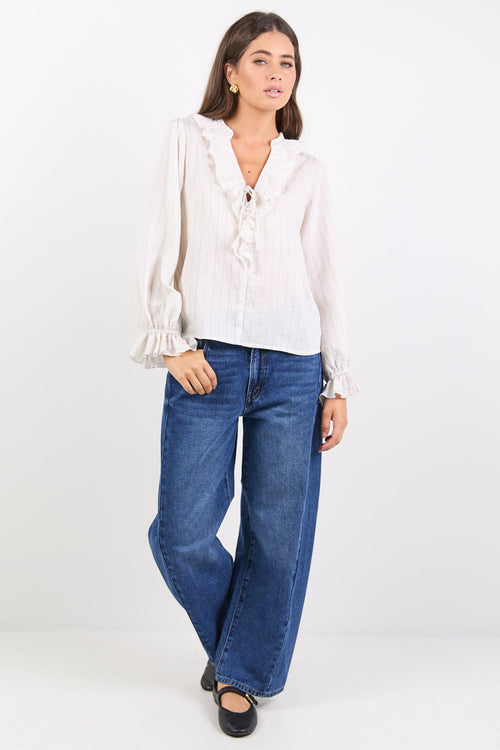 Woman wearing a white blouse and blue jeans on a white background