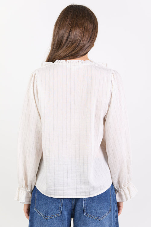 Woman wearing a white blouse and blue jeans on a white background
