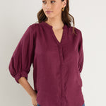 burgundy blouse on model 