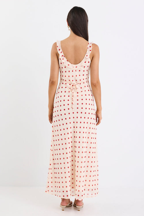 Woman wearing a long, sleeveless dress with a pattern on a white background