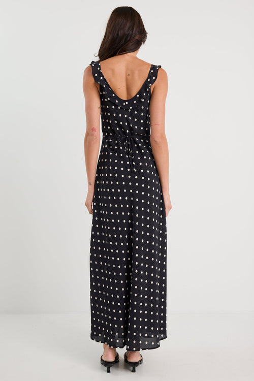 Woman wearing a black dress with white polka dots on a white background