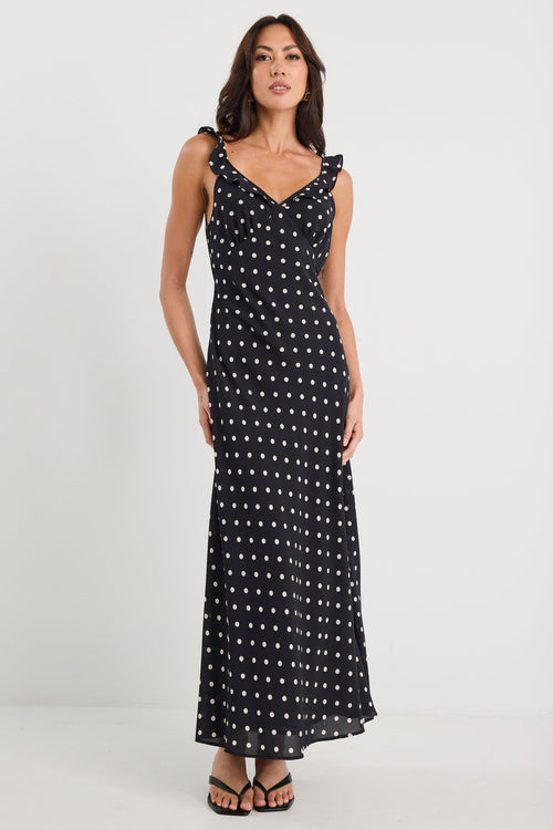 Woman wearing a black dress with white patterns on a white background