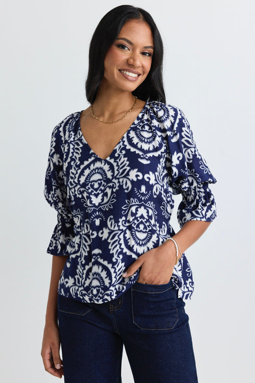 model wears a navy print blouse