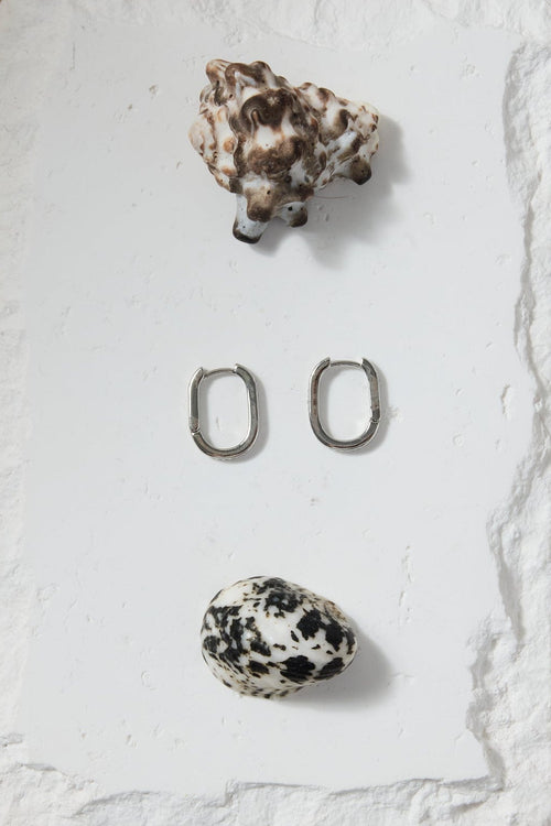 Set of earrings on a white stone surface with a beige background