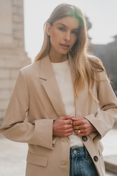 Woman wearing a beige coat with a blurred background