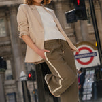 Woman standing on a street light with a blurred cityscape background