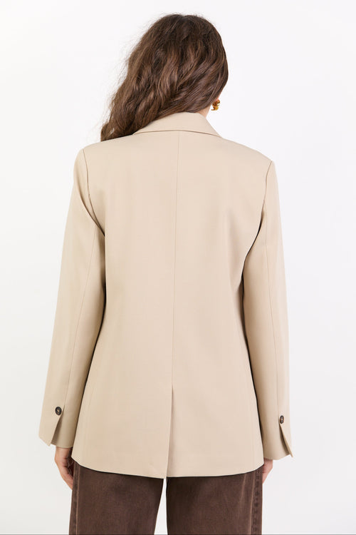 Beige blazer worn by a person on a white background
col_pattern