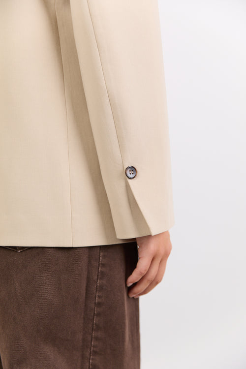 Beige blazer with a button on a white background