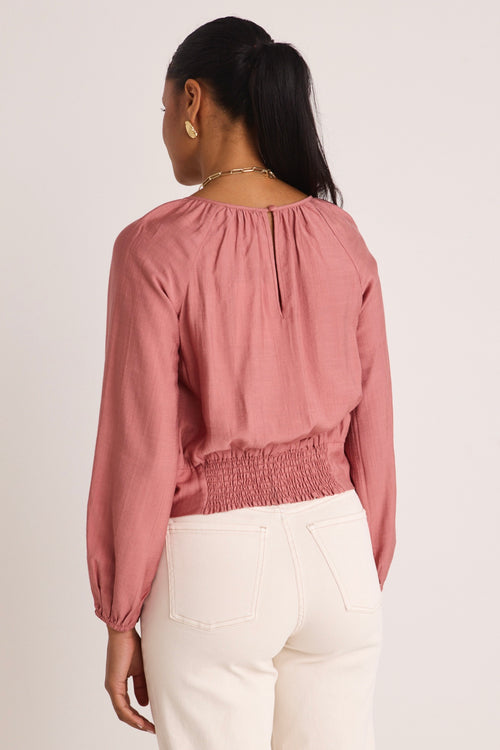 model wears a pink blouse 