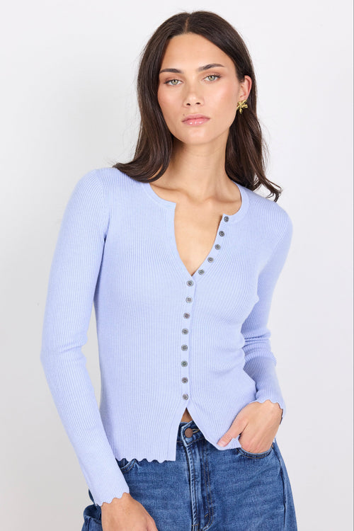 Woman wearing a light blue cardigan with a white background