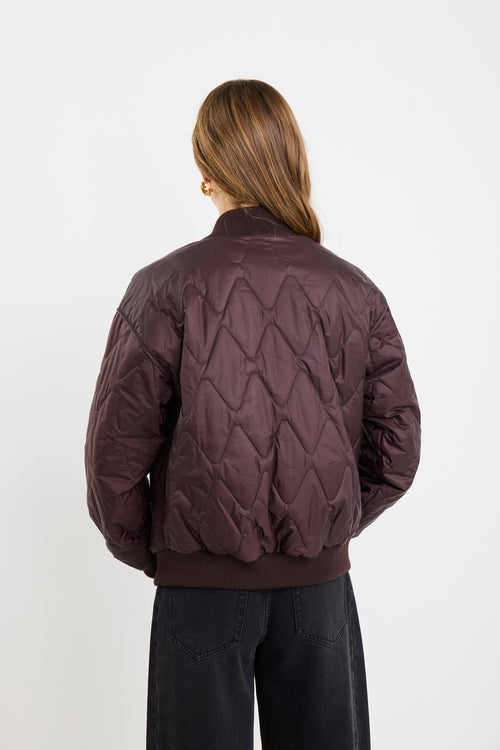 Person wearing a quilted jacket on a white background