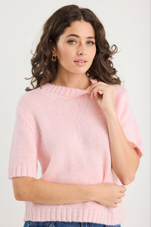 Woman wearing a pink sweater against a white background