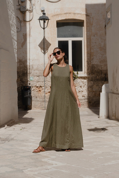 model wears a green maxi dress outside with sunglasses on