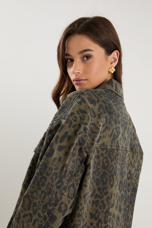 Woman wearing a leopard print jacket against a plain background