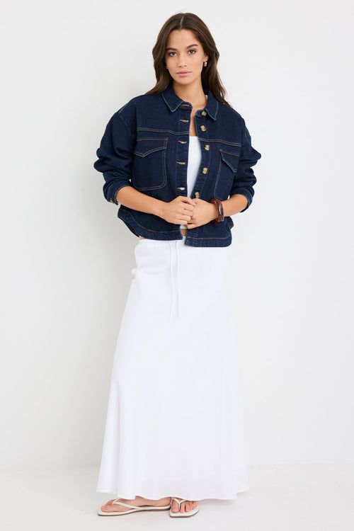 Long sleeve indigo denim jacket with patch pockets, buttoned front, and relaxed fit on model.