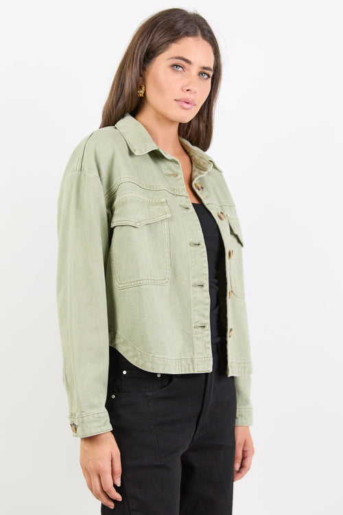 Woman wearing a light green jacket on a white background